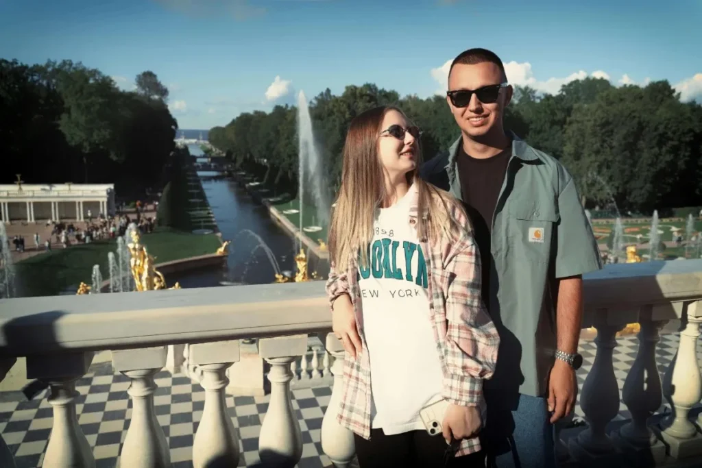 Smiling couple on a terrace with fountains, reflecting a joyful day and love compatibility test